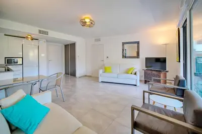 a living room with a couch and a table at Appartement , piscine, terrasse, proche croisette in Cannes