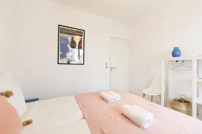 a white bedroom with two towels on a bed at Cannes Victoria YourHostHelper in Cannes