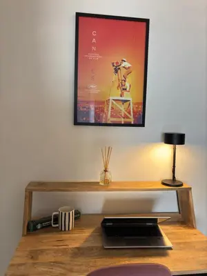 a desk with a laptop and a picture on the wall at Cannes Victoria YourHostHelper in Cannes