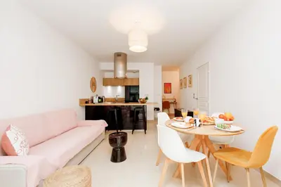a living room with a white couch and a table at Cannes Victoria YourHostHelper in Cannes