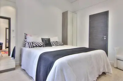 a bedroom with a large bed with black and white pillows at Appartement Cannes 4 chambres - 5G in Cannes