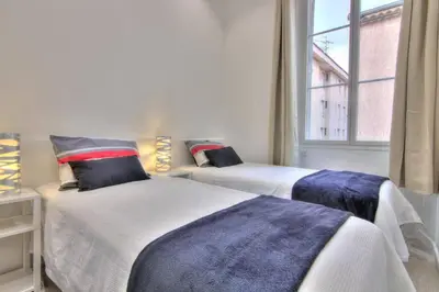 two beds in a room with a window at Appartement Cannes 4 chambres - 5G in Cannes