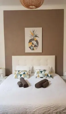 a white bed with two slippers on top of it at Appartement Canne 1 chambre - 21JOFFRE in Cannes