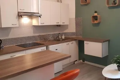 a kitchen with white cabinets and a wooden counter top at Appartement Canne 1 chambre - 21JOFFRE in Cannes