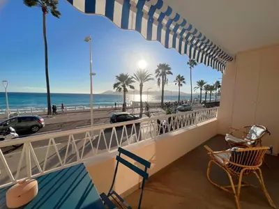 a balcony with a view of the beach and palm trees at Marjolaine luxury sea view, by Welcome to Cannes in Cannes