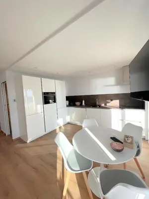 a white kitchen with a white table and chairs at Marjolaine luxury sea view, by Welcome to Cannes in Cannes
