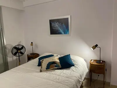a bedroom with a bed with blue pillows on it at superbe 2 pièces à Cannes vue imprenable in Cannes