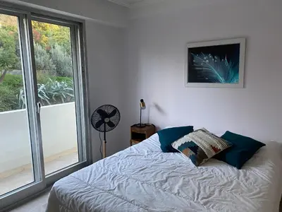 a bedroom with a bed and a large window at superbe 2 pièces à Cannes vue imprenable in Cannes
