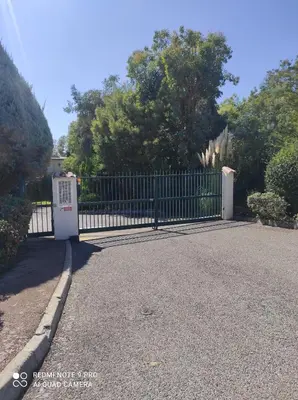 a black fence with a white door in a driveway at superbe 2 pièces à Cannes vue imprenable in Cannes