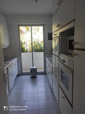 a kitchen with white appliances and a large window at superbe 2 pièces à Cannes vue imprenable in Cannes