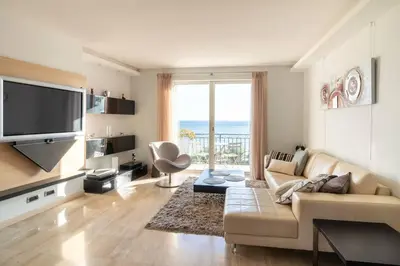 a living room with a couch and a large window at T3 vue mer LE MACE PLAGE in Cannes