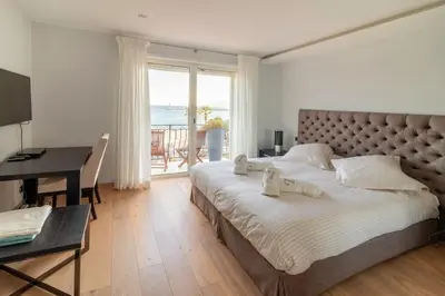 a bedroom with a large bed with a desk and a piano at T3 vue mer LE MACE PLAGE in Cannes