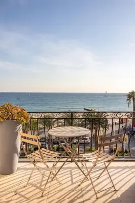 a table and chairs on a balcony overlooking the ocean at T3 vue mer LE MACE PLAGE in Cannes