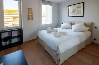 a bedroom with a large white bed with towels on it at T3 vue mer LE MACE PLAGE in Cannes