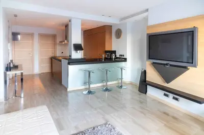 a kitchen with a large flat screen tv and stools at T3 vue mer LE MACE PLAGE in Cannes