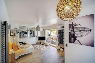 a living room with a couch and a chandelier at Beautiful 28m2 studio with balcony in Cannes