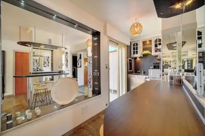 a kitchen with a large glass window with a table at Beautiful 28m2 studio with balcony in Cannes