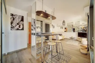 a kitchen and living room with a table and stools at Beautiful 28m2 studio with balcony in Cannes