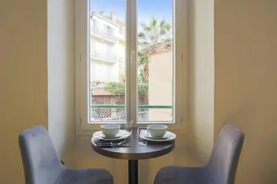 a table and two chairs and a window at Studio Nid Doré - Welkeys in Cannes