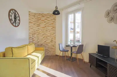 a living room with a yellow couch and a table at Studio Nid Doré - Welkeys in Cannes