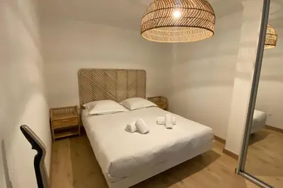 a bedroom with a bed with white sheets and pillows at Appartement 2 pièces (Banane) in Cannes