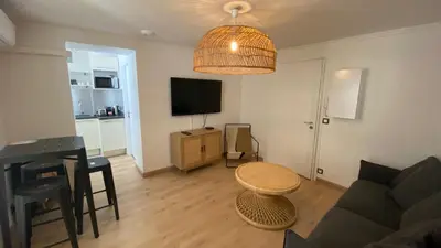 a living room with a couch and a table at Appartement 2 pièces (Banane) in Cannes