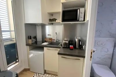 a small kitchen with white cabinets and a microwave at Appartement 2 pièces (Banane) in Cannes