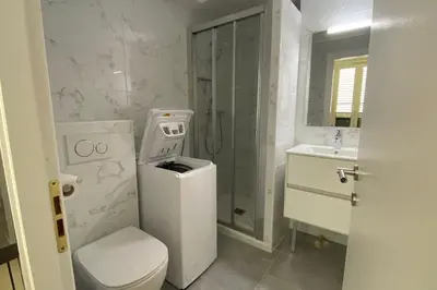 a white bathroom with a toilet and a sink at Appartement 2 pièces (Banane) in Cannes