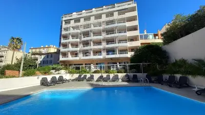 a hotel with a swimming pool in front of a building at Les Félibriges in Cannes