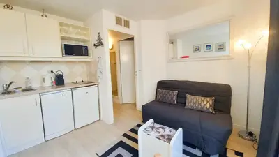 a living room with a couch and a kitchen at Les Félibriges in Cannes