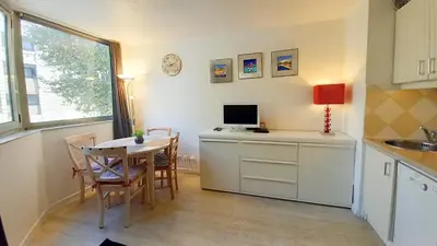 a kitchen with a table and a computer on a counter at Les Félibriges in Cannes