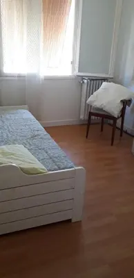 a bedroom with a bed and a chair and a window at Joli appartement vue sur mer in Cannes