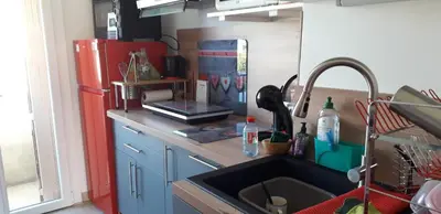 a kitchen with a sink and a red refrigerator at Joli appartement vue sur mer in Cannes