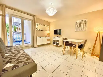 a living room with a table and a bedroom at Appartement Canne 1 chambre - 52C in Cannes