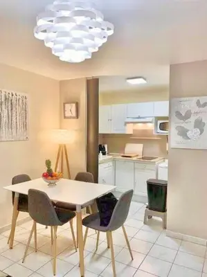 a kitchen with a table and chairs and a chandelier at Appartement Canne 1 chambre - 52C in Cannes
