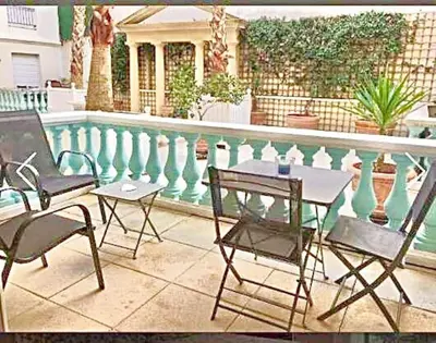 a patio with a table and chairs next to a pool at Appartement Canne 1 chambre - 52C in Cannes