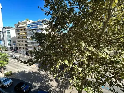 a tree with cars parked next to a building at Carnot in Cannes
