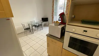 a kitchen with a table with chairs and a counter top at Modest one bedroom apartment in Cannes