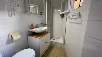 a white bathroom with a sink and a toilet at Modest one bedroom apartment in Cannes