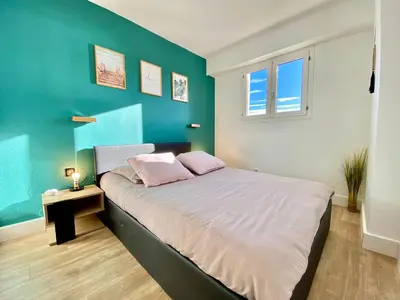 a bedroom with a bed with a blue wall at Cannes Les Plages By SCLS Locations in Cannes