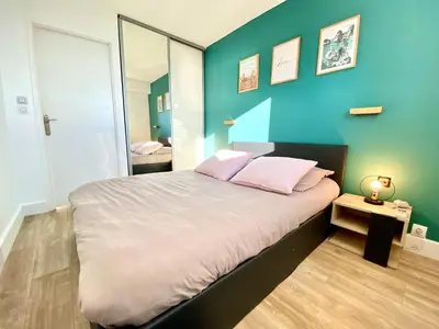 a bedroom with a large bed with a blue wall at Cannes Les Plages By SCLS Locations in Cannes