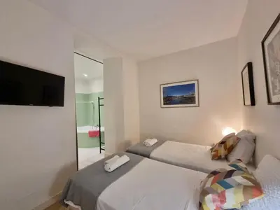 a bedroom with two beds and a television in it at CLEMENCEAU Plage Palais Cannes in Cannes