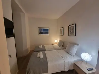 a bedroom with a bed with two white towels on it at CLEMENCEAU Plage Palais Cannes in Cannes