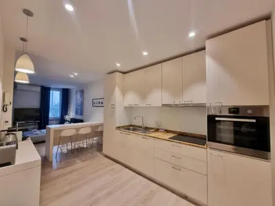 a large kitchen with white cabinets and a counter top at CLEMENCEAU Plage Palais Cannes in Cannes