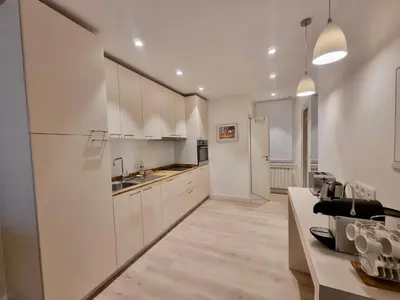 a kitchen with white cabinets and a counter top at CLEMENCEAU Plage Palais Cannes in Cannes