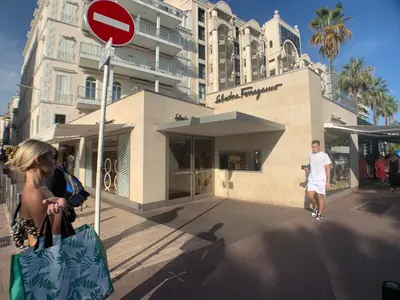 a man and a woman with shopping bags in front of a building at Appartement Commandant André in Cannes