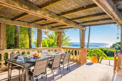 a dining room with a table and chairs on a patio at LE CASTEL ROSE Super Cannes, face aux Îles de Lérins in Vallauris