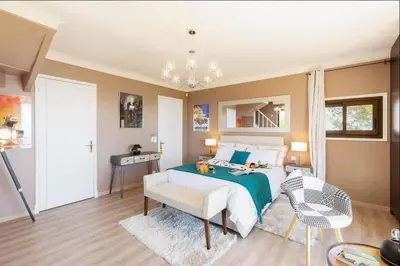 a bedroom with a bed and a table and a chair at LE CASTEL ROSE Super Cannes, face aux Îles de Lérins in Vallauris