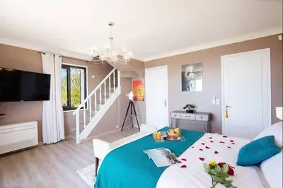 a bedroom with a large bed with a blue blanket at LE CASTEL ROSE Super Cannes, face aux Îles de Lérins in Vallauris