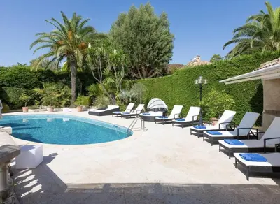 a pool with chaise lounge chairs and a bunch ofitures at LE CASTEL ROSE Super Cannes, face aux Îles de Lérins in Vallauris